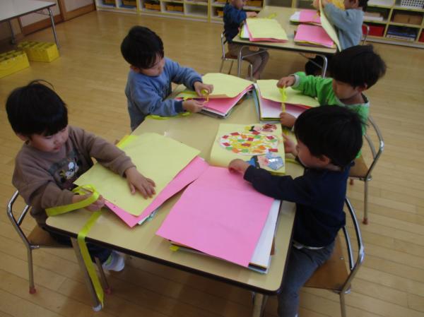 一枚一枚の絵の穴に、慎重にリボンを通して…👀✨