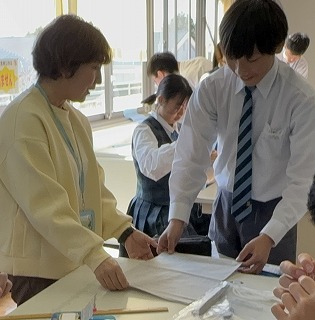 ボランティアの保護者が手提げ袋づくりをサポート