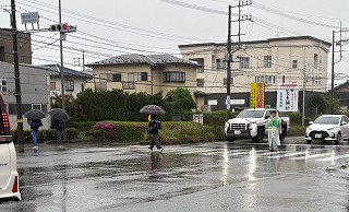 雨の朝も変わらぬ見守り 交通安全協会が交差点で支援