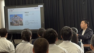 旅行会社社員から、職場体験学習先の説明を受ける